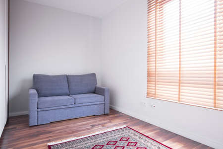 Empty white room with sofa and wooden parquetの写真素材
