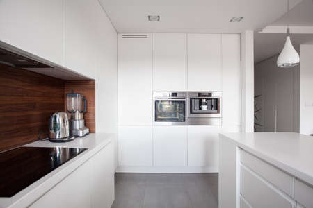 Elegant cozy kitchen with white units and marble floorの写真素材