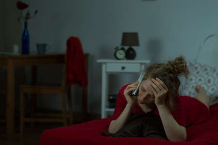 Young woman is missing fer family so she is callingの写真素材