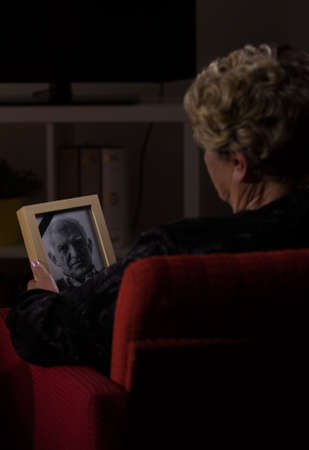 Old widow loved very much her now dead husbandの写真素材