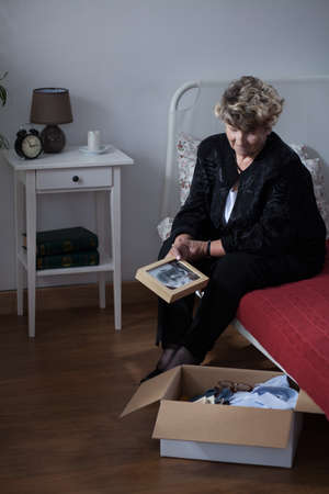 Old widow cannot throw out husband's stuffの写真素材