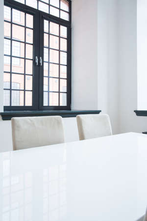 Vertical view of white table in dining hall with big windowの写真素材