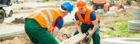 Workers are lifting heavy cement construction, panorama