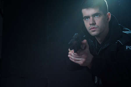 Portrait of a handsome focused officer looking on aimの写真素材