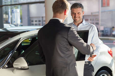Happy mature man buying new beauty carの写真素材