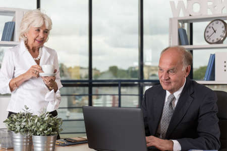 Image of mature woman talking to senior manager in office