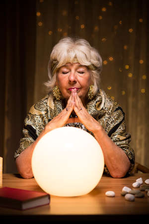 Image of fortune teller using magic ball during seanceの写真素材