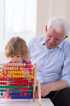 Patient loving granddad learning grandson math on abacusの写真素材