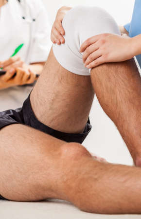 Male patient with painful knee during rehabilitationの写真素材