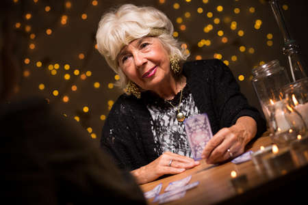 Image of smiling elderly female seer during seanceの写真素材