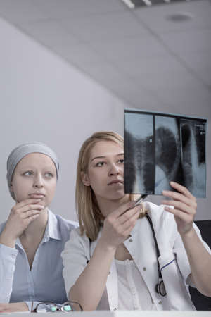 Young pretty doctor checking patient's test resultsの写真素材