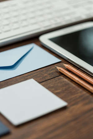 Small blue envelope and two pencils prepared on desk officeの写真素材