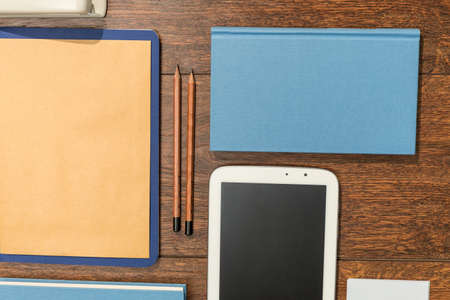 Tablet, books and papers set on wooden desk officeの写真素材