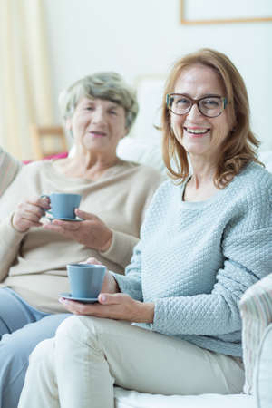 Photo of two content smiling mature friends