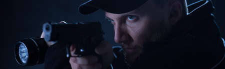 Serious police officer is aiming to the bandit