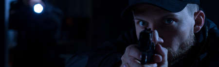 Close up of policeman aiming to the bandit