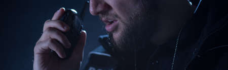 Police officer is using his shortwave radio during intervention