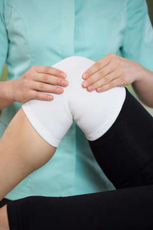 Close-up of patient's knee with stabilizing bandの写真素材