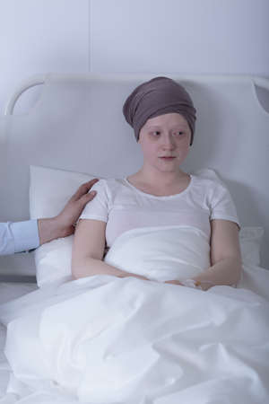 Sick tired young woman with neoplasm in hospitalの写真素材