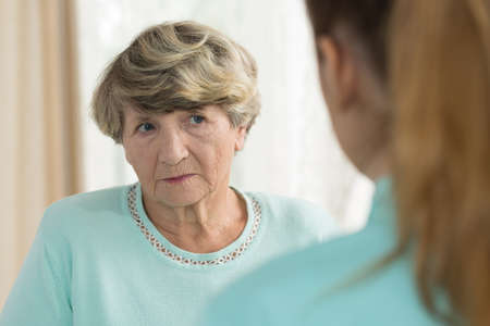 Close up of sad senior female in professional nursing homeの写真素材