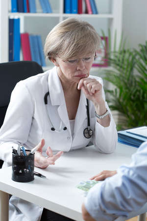 Portrait of elder doctor refusing a bribeの写真素材