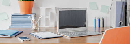 Panorama of laptop and mobilephone lying on wooden desk