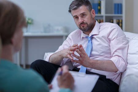 Image of depressed man listening his therapist adviceの写真素材