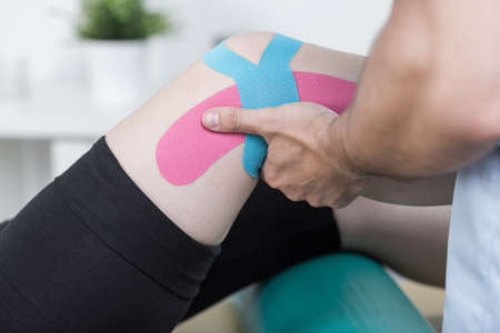 Physiotherapist training with patient after knee injuryの写真素材