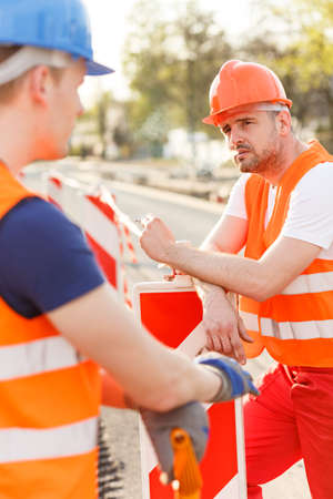 Male construction workers smoking cigarette during breakの写真素材