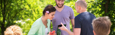 Panorama of young people enjoying summer on backyard patioの写真素材
