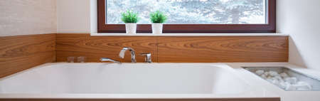 Panorama of big bathtub with ceramic wood imitation backsplashの写真素材