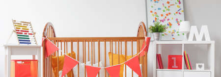 Wooden crib in beautiful baby nursery - panoramaの写真素材