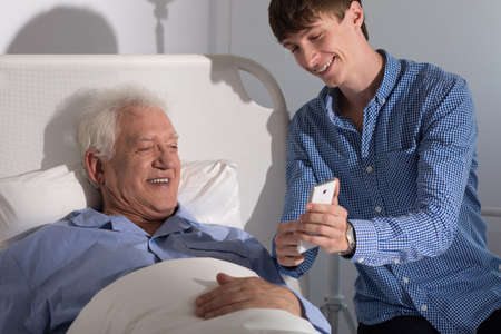 Picture of grandfather and grandson with smartphoneの写真素材