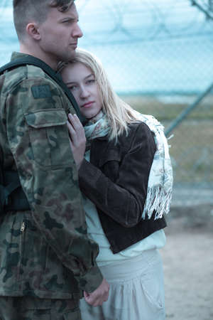 Sad woman hugging military husband and saying goodbyeの写真素材