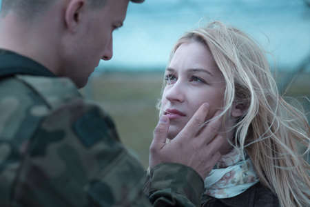Soldier saying goodbye to beauty upset wifeの写真素材