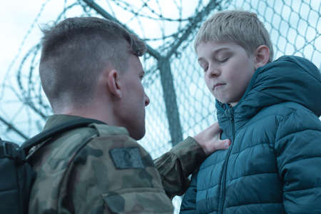 Upset son and military dad saying goodbyeの写真素材