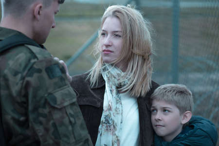 Military soldier saying goodbye to wife and sonの写真素材