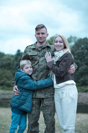 Soldier in military uniform and happy family