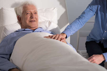 Portrait of ill man supported by son