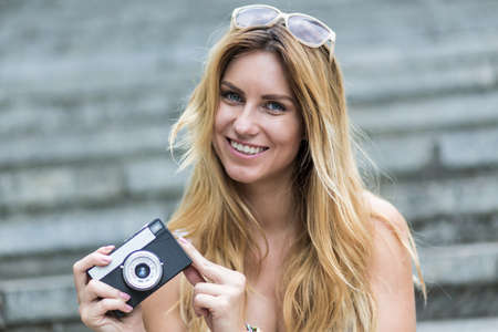 Portrait of smiling woman taking photos during summer holidayの写真素材
