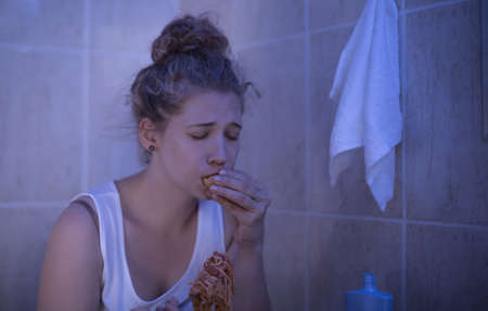 Image of overeating teenage bulimic ashamed of her problemの写真素材