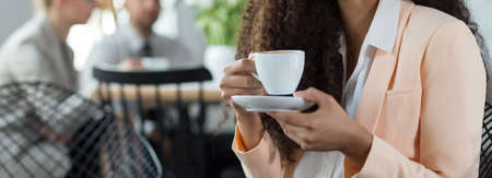 Young woman is drinking coffee in the restaurantの写真素材