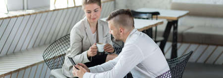 Young man is showing his new mobile phoneの写真素材