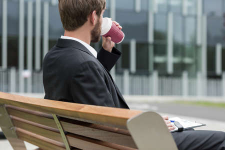 Man is filling out documents and drinking coffeeの写真素材