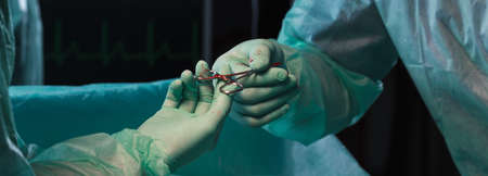 Closeup of surgeons' hands holding pliers during operationの写真素材