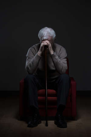 Hopeless disabled retiree sitting in an armchairの写真素材