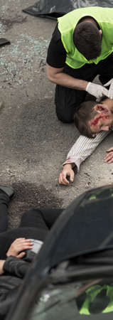 Policeman is helping injured man in car accidentの写真素材