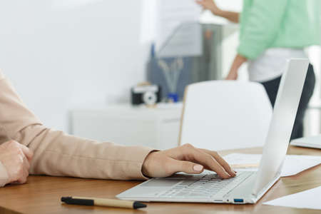 Close-up of woman using laptop at workのeditorial素材