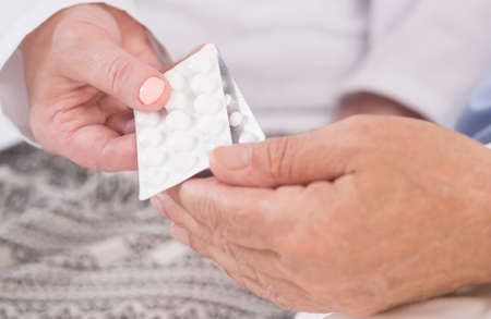 Close-up of hands holding blister of tabletsの写真素材