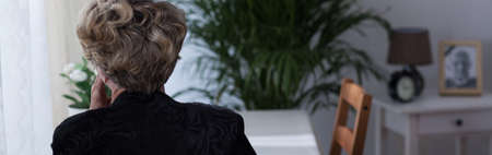 Sad despair widow being alone at homeの写真素材